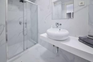 a white bathroom with a sink and a shower at LUKA in Budva +18 photos