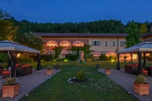 dziedziniec ze stołami i parasolami przed budynkiem w obiekcie Tenuta Pian D'Attesio - Agriturismo w mieście Castelletto Soprano