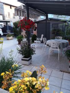 a patio with a table and chairs and flowers at Chambre d'Hôtes Chez Eliane et Bernard in Lisle-sur-Tarn