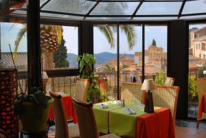 un restaurante con mesa y vistas a la ciudad en Hotel Restaurant Bellevue, en Bormes-les-Mimosas