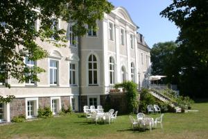 a group of chairs in front of a building at Schloss Zinzow in Zinzow