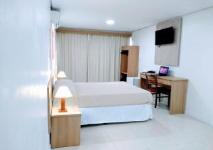 a hotel room with a bed and a desk at Dan Inn Express Porto Alegre - próximo a Santa Casa in Porto Alegre