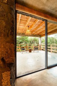 a large glass door leading to a patio with a chandelier at Pocinhobay in Madalena