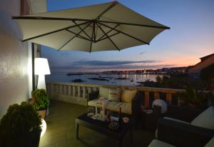 an umbrella on a balcony with a view of a harbor at Principe in Sanxenxo