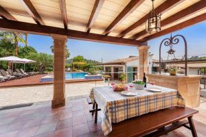 a patio with a table and a pool at Finca Morell Vell in Pollença