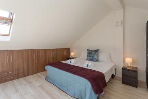 sypialnia z dużym łóżkiem i drewnianymi szafkami w obiekcie BeGuest Parede Beach Apartment – Cascais w mieście Parede