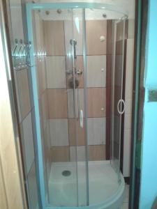 a shower with a glass door in a bathroom at Przytulne na Poddaszu in Jelenia Góra