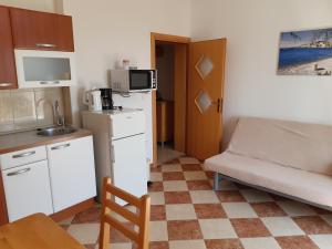 a small room with a kitchen and a couch at Apartments Primosten in Primošten