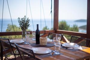 a wooden table with a bottle of wine and glasses at Glamping Tents and Mobile Homes Trasorka in Veli Lošinj