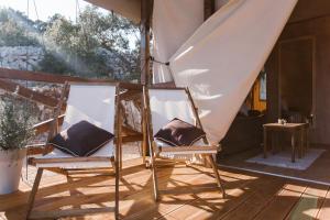 an open umbrella sitting on top of a wooden table at Glamping Tents and Mobile Homes Trasorka in Veli Lošinj