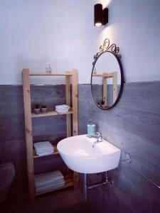 un bagno con un lavandino bianco e uno specchio di La Foresteria a Grottaglie