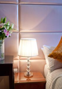 una lámpara en una mesa junto a una cama en City Inn Russell Square en Londres