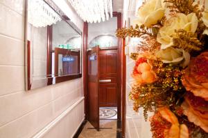 korytarz prowadzący do drzwi z kwiatami na ścianie w obiekcie City Inn Russell Square w Londynie