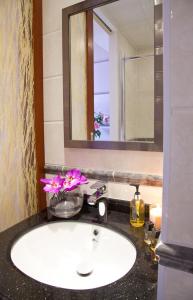 La salle de bains est pourvue d'un lavabo blanc et d'un miroir. dans l'établissement City Inn Russell Square, à Londres