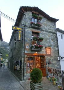 a stone building with flower boxes on the side of it at Casa A Ruata in Torla