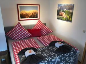 ミッテンヴァルトにあるALPENFREUNDの赤と白の枕が備わる客室内のベッド2台