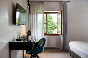 a bedroom with a desk and a chair and a window at Horto Convento in Florence