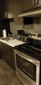 a kitchen with a stainless steel stove and a sink at Paradis de vacances in Quebec City
