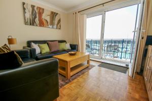 a living room with a couch and a large window at Britannia Harbour View - Parking - by Brighton Holiday Lets in Brighton & Hove