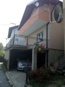 un'auto parcheggiata all'interno di un garage accanto a una casa di Apartmani "Babići" a Banja Luka