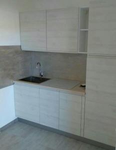 a kitchen with white cabinets and a sink at La Cinta in San Teodoro