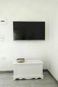 a tv on a wall with a bowl on a white table at La Cinta in San Teodoro