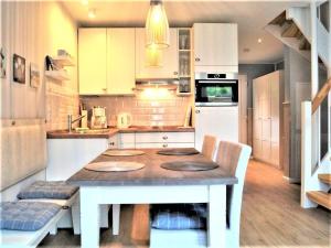 a kitchen with a table and chairs in it at Sandkorn-H in Hohwacht +8 photos