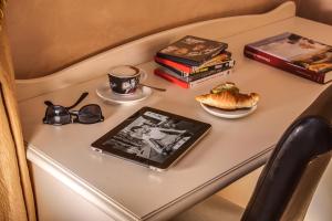 una mesa con una tableta y una taza de café y libros en Quality in Rome, en Roma
