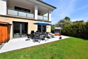 a patio with chairs and an umbrella in front of a house at Seestern in Hohwacht