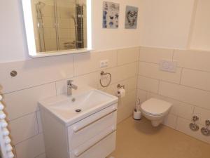 a white bathroom with a sink and a toilet at Seestern in Hohwacht +14 photos