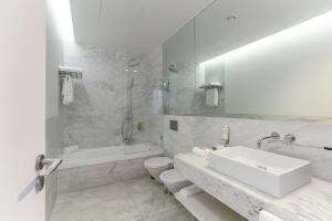 a bathroom with a sink and a tub and a toilet at Santiago Hotel in Santiago do Cacém +57 photos
