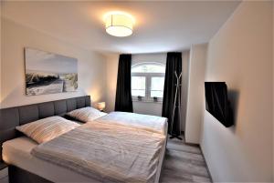 a bedroom with a bed and a window at Ostseeblick-Laue-Wohnung-8-H in Hohwacht