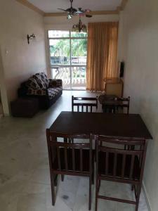 uma sala de estar com uma mesa e cadeiras e um sofá em Apartment at Glory Beach Resort em Porto Dickson