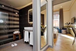 a bathroom with a large mirror and a tub at Roma Five Suites in Rome