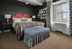 a bedroom with a bed with a red headboard and a bench at Graduate Providence in Providence