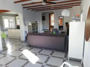 a kitchen and a living room with a couch and a tile floor at Adel Locdenia in Els Poblets