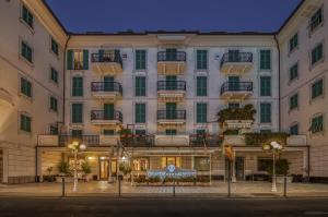 un gran edificio blanco con un cartel delante en Grande Albergo, en Sestri Levante