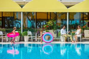 una famiglia che gioca in piscina in un resort di Hotel Parco Dei Principi a Giulianova