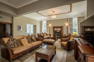 a living room with couches and a piano at Carlogie House in Carnoustie