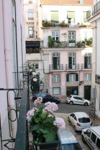 un balcón con flores en la cornisa de un edificio en Lost Inn Lisbon Hostel, en Lisboa