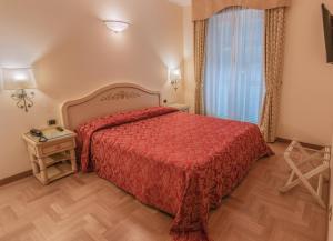 a bedroom with a red bed and a window at Grande Albergo in Sestri Levante