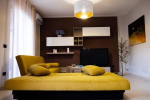 a bedroom with a yellow bed and a television at ALMI B&B in Sarno