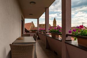 - un balcon avec une table, des chaises et des fleurs dans l'établissement B&B Relais du Vigneron - Jean-Luc et Bruno Meyer, à Eguisheim