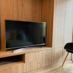 a flat screen tv sitting on a wooden wall at Maxim Apartment in Mavrovo