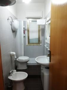 Baño blanco con 2 aseos y lavamanos en Appartamento Ginepri, en Lamezia Terme