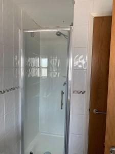 La salle de bains est pourvue d'une douche avec une porte en verre. dans l'établissement 2 Bed Duplex Penthouse Apartment by Mathew Street Sleeps 6, à Liverpool
