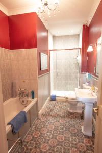 a bathroom with a tub and a toilet and a sink at Penrose Bed & Breakfast in Lostwithiel