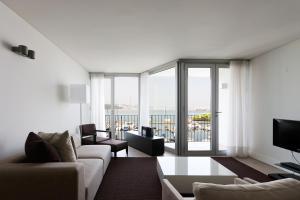 - un salon avec un canapé et une grande fenêtre dans l'établissement Troia Residence by The Editory - Apartamentos Marina, à Tróia