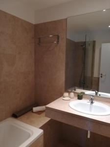 a bathroom with a sink and a tub and a mirror at Residence Golf Club, Vilamoura in Vilamoura