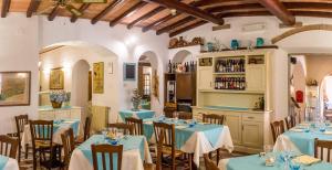 a restaurant with tables and chairs with blue tablecloths at Hotel Elba in Marina di Campo +45 photos
